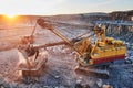 Mining. excavator loading granite or ore into dump truck