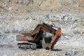 Mining industry. Big crawler orange excavator with a bucket in a granite quarry Royalty Free Stock Photo