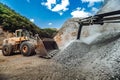 Mining industry - Heavy duty wheel loader bulldozer loading granite rock or ore at crushing Royalty Free Stock Photo