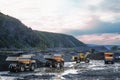 Mining trucks are queuing, in the background a wheel loader is loading mountain soil into the bodies of these trucks Royalty Free Stock Photo