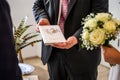 Minister hoding family book written in german stammbuch in front of Wedding flowers held by bride closeup. yellow roses Royalty Free Stock Photo