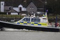 A Ministry of Defence Police boat sets out on a patrol from Plymouth Navy Base in Devon with the village of Cremyll behind it.