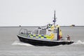 A Ministry of Defence Police boat sets out on a patrol from Plymouth Navy Base in Devon with the village of Cremyll behind it.