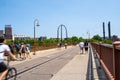 Minneapolis, Minnesota - June 1, 2019: Pedestrians and bikers enjoy a beautiful spring day walking over the Stone Arch Bridge in Royalty Free Stock Photo