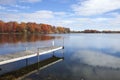 Minnesota lake and dock with trees in full autumn color, blue sk