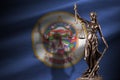 Minnesota US state flag with statue of lady justice and judicial scales in dark room. Concept of judgement and