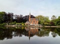 Minnewater ancient medieval red brick castle at the Lake of Love in Bruges in public park zone, Belgium Royalty Free Stock Photo