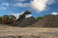 Crushing machinery, cone type rock crusher, conveying crushed granite gravel stone in a quarry open pit mining. Minning industry Royalty Free Stock Photo