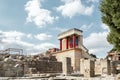Minoan palace Knossos at Heraklion, Crete island, Greece. Bull fresco and three red columns against dramatic cloudy sky Royalty Free Stock Photo