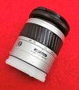 Minolta AF Zoom 28-80mm Macro lens resting on red background Royalty Free Stock Photo