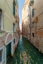 Minor side canal between two ancient buildings in Venice, Italy Royalty Free Stock Photo