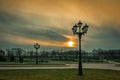 MINSK, BELARUS - Apr. 15, 2018: alleys with street lights in an evening park against a cloudy sky and sunset