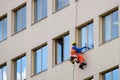 Industrial climber washes windows on facade of a building. Side view Royalty Free Stock Photo