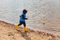 Minsk, Belarus, April, 18, 2020. Little boy runs along the lake on a sunny day