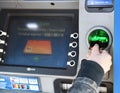 MINSK BELARUS-04.30.2020: ATM close-up with woman hand.NCR SelfServ Cash Dispense ATMs.Girl with a PAYONEER card at an ATM withdra Royalty Free Stock Photo