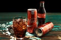 MINSK, BELARUS-AUGUST 25, 2016. Can and a glass of iced Coca-Cola on a wooden table