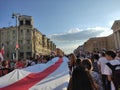 Minsk / Belarus - August 16 2020: Demonstrators carrying a huge white-red-white flag on the roadway in the capital center -