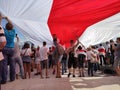 Minsk / Belarus - August 16 2020: Demonstrators holding a huge white-red-white flag at the stairs of the Minsk Hero City Obelisk