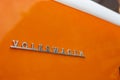 Minsk, Belarus, August 14 2018 - Orange Volkswagen Type 2 VW T2 parked on the street Logo Close-up shot, known as the Royalty Free Stock Photo