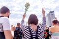 Minsk, Belarus - August 15, 2020. Protest actions in Minsk. Woman with hands raised up. In one hand she holds flowers and in the