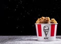 Minsk, Belarus - December 03, 2021: black background, night. Lots of hot wings or strips of KFC chicken in a KFC Kentucky Fried