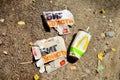 Discarded paper coffee cups, cola and fast food packaging on the ground.