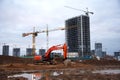 Excavator HITACHI ZAXIS 270LC and tower cranes POTAIN working at construction site. Construction