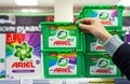 MINSK, BELARUS - February 2, 2020: A buyer takes Ariel washing powder from a supermarket shelf. Woman purchases washing powder at