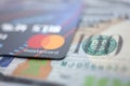 Embossed chipped mastercard credit card and hundred dollar bank notes closeup