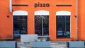 MINSK, BELARUS - FEBRUARY 20, 2022: Pizzeria. View of the facade of the building with the inscription pizza and windows.
