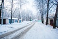 Car tracks left on snowy slippery road in winter. Trees in hoarfrost