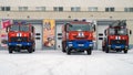 Three fire trucks near the building of fire rescuers. Front view