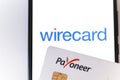 Minsk, Belarus- June 27 2020: Payoneer card and smartphone with wirecard logo on the screen. Payoneer funds were recently put on Royalty Free Stock Photo