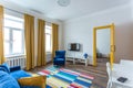 MINSK, BELARUS - March, 2019: retro bright interior of hipster flat apartments with blue sofa, yellow door and colored carpet Royalty Free Stock Photo