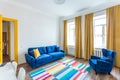 MINSK, BELARUS - March, 2019: retro bright interior of hipster flat apartments with blue sofa, yellow door and colored carpet Royalty Free Stock Photo