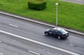 Aerial view on Yandex Taxi passenger car rides on the wet road. Small roughness sharpness, possible