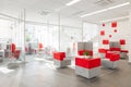 Minsk, Belarus - May 23, 2019: Corner of modern office with white walls, gray floor, open space area with red-white Royalty Free Stock Photo