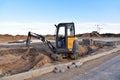 Mini Excavator VOLVO at constrruction site on road work. Laying paving slabs and borders. Process of