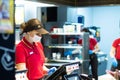 Minsk, Belarus 03.10.2020: McDonald`s employee at the cash register wearing a mask and gloves during a pandemic