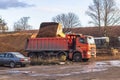 Minsk. Belarus. 2020, November, 24. A big red car is under loading. The loader pours sand into the body Royalty Free Stock Photo