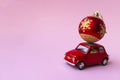 Minsk, Belarus, 23 november 2020. Concept christmas background. Red retro toy car delivering Christmas or New Year gifts, ball, on Royalty Free Stock Photo