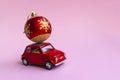 Minsk, Belarus, 23 november 2020. Concept christmas background. Red retro toy car delivering Christmas or New Year gifts, ball, on Royalty Free Stock Photo