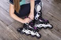 Minsk, Belarus, October 20, 2019. Little girl dresses pink roller skates on a wooden floor