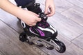 Minsk, Belarus, October 20, 2019. Little girl dresses pink roller skates on a wooden floor