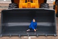 Minsk, Belarus, September 20, 2022: Child, boy posing inside bucket of excavator, road car loader