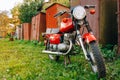 Old Red Russian Soviet Motorcycle Voshod Parked On Green Grass in Countryside Royalty Free Stock Photo