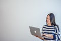 MINSK. BELARUS - SEPTEMBER 2015: Pretty woman works on Apple laptop against gray wall background.