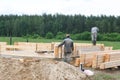 Minsk Region. Belarus. February 24, 2016. Workers drill holes for driving Nagel. construction of bony from natural wood