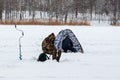 Winter fishing. Fishermen on the ice of the reservoir with a tent and fishing