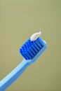 Blue toothbrush with toothpaste on a green background, close-up. Mint background. Royalty Free Stock Photo